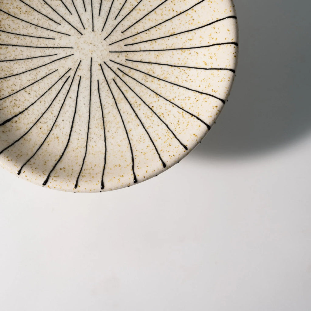 Black and white striped resin fruit plate on a table for dessert serving.