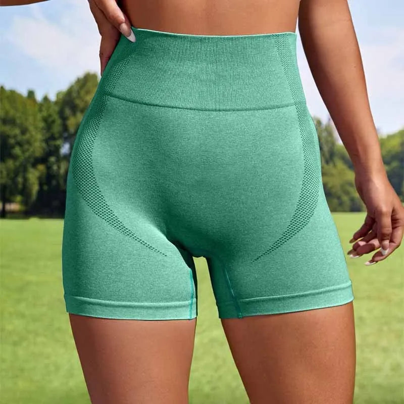 Women's seamless high-waisted sport leggings shorts in a solid colour, shown folded, for yoga and gym training.