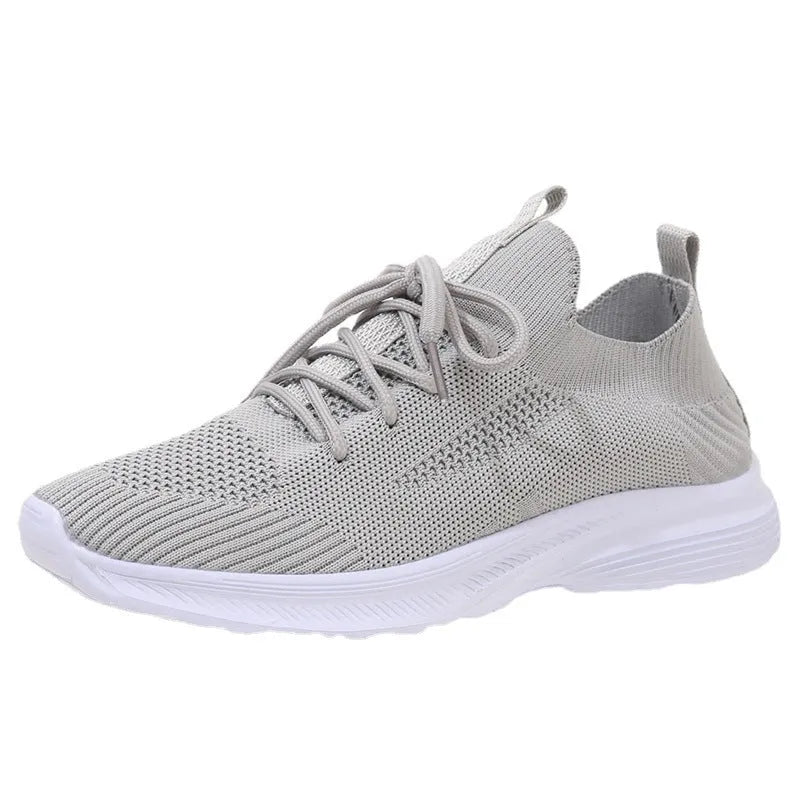 Women's mesh running shoes in creamy white with Flyknit upper and flat rubber sole