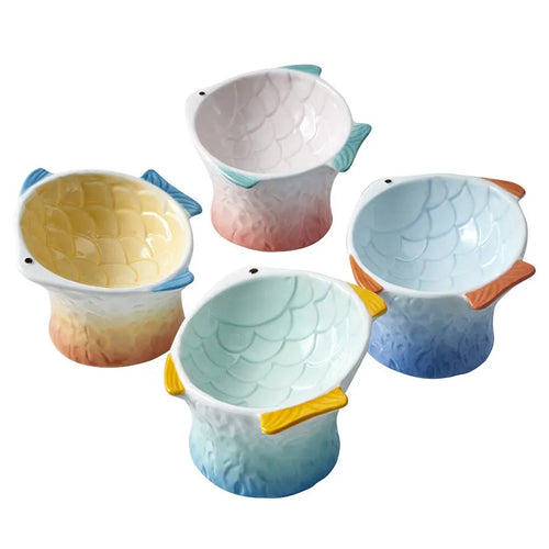 Four fish-shaped ceramic cat bowls in assorted colours with elevated design and tilted angle