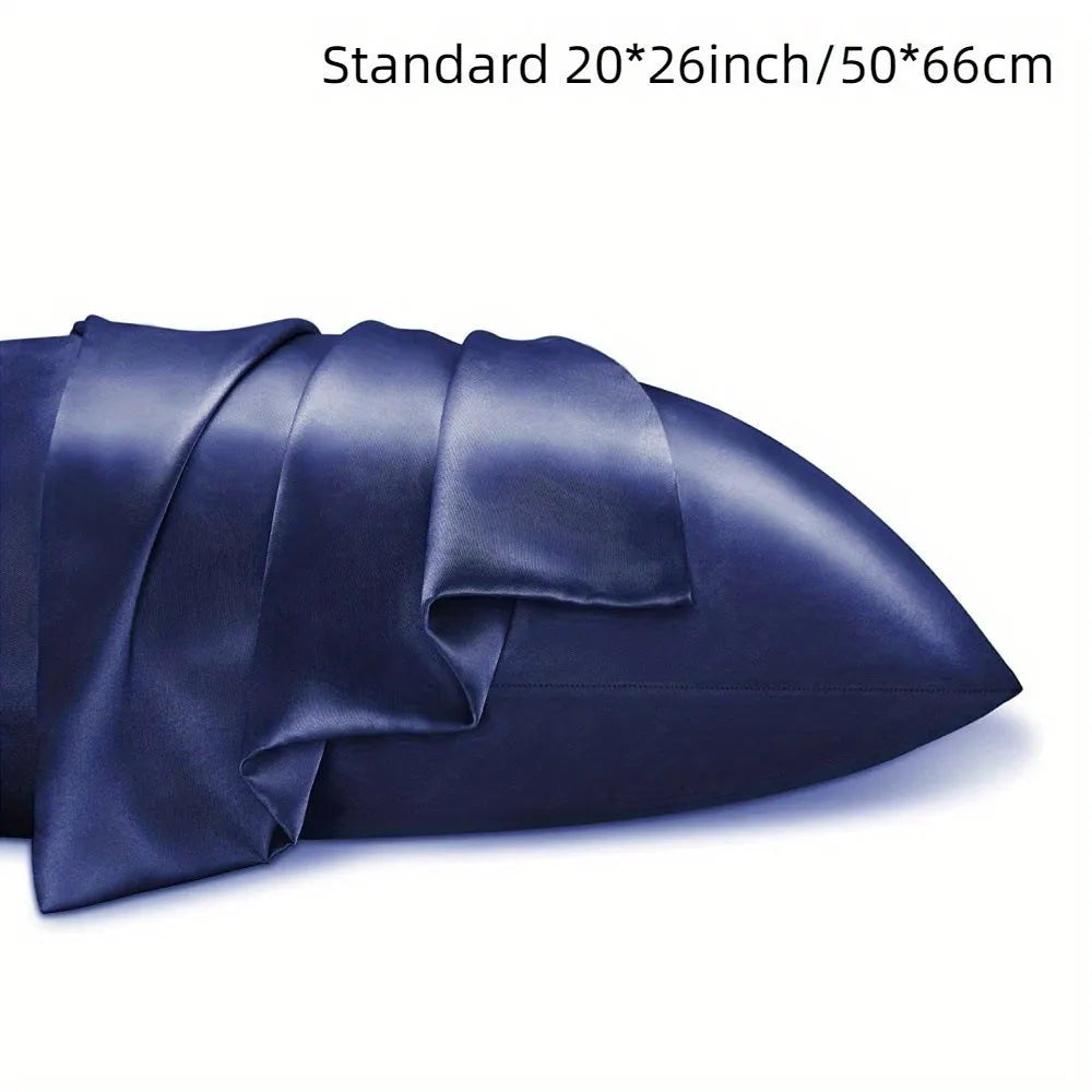 A pair of solid colour satin pillowcases in various colours and sizes on a bed.