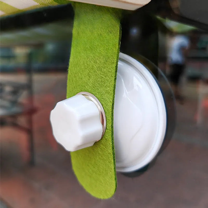 Wooden frame cat hammock with linen cushion mounted on a window, shown in green colour.