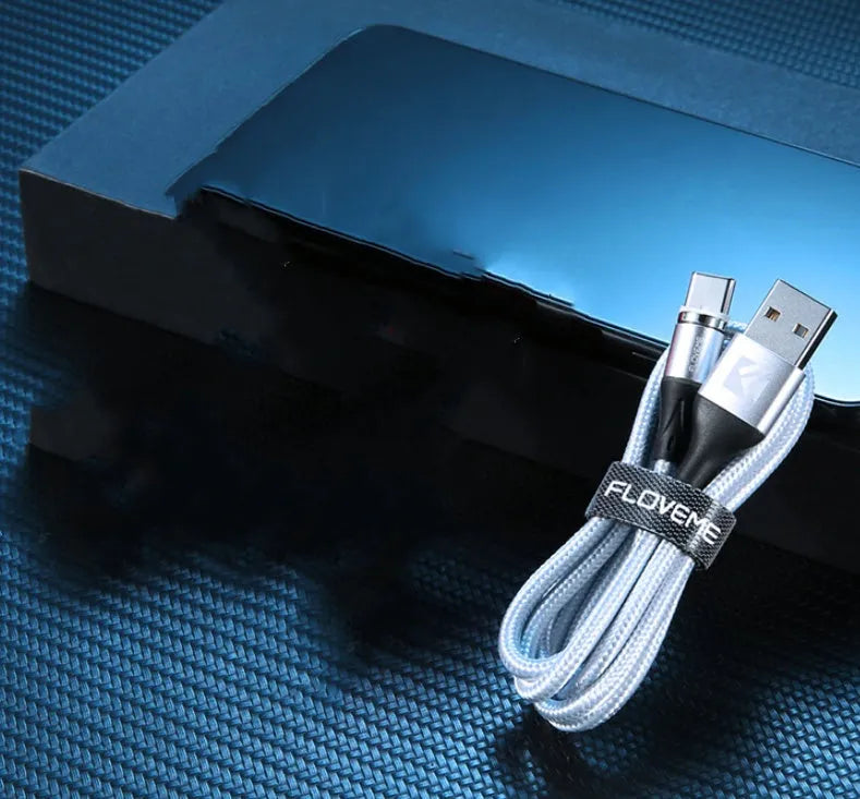 A black magnetic fast-charge data cable with LED light on the connector, next to a smartphone.
