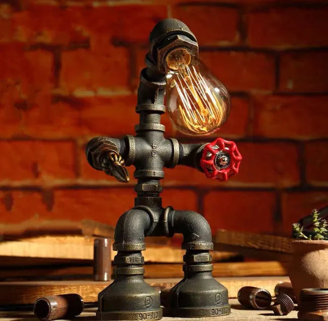 Green bronze vintage industrial robot desk lamp with iron pipe design on a wooden table.