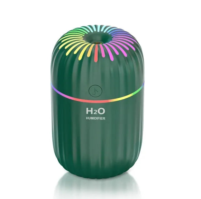 Small white Fireworks USB desktop humidifier with water tank on a wooden desk.
