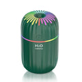 Small white Fireworks USB desktop humidifier with water tank on a wooden desk.