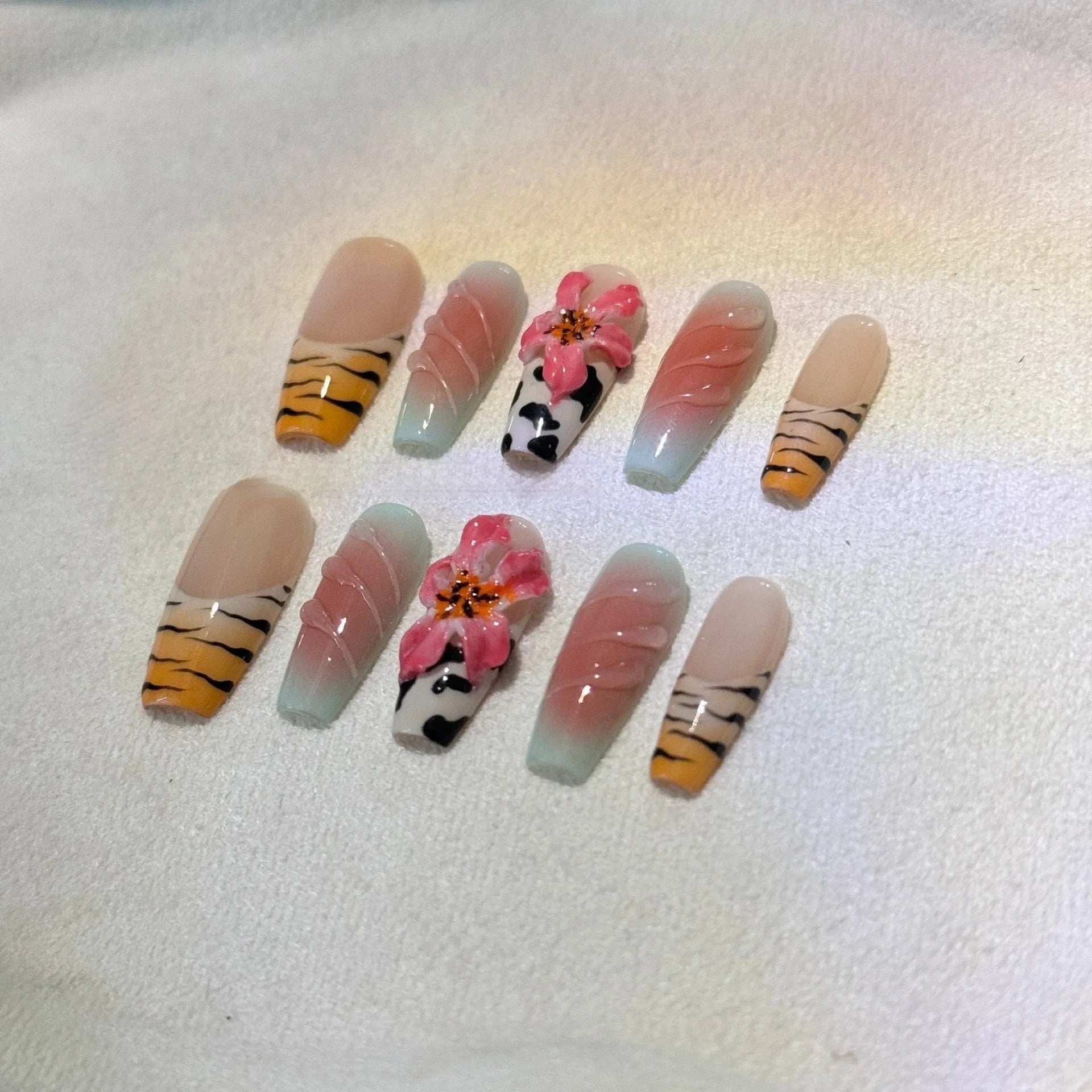Set of nail art stickers showing zebra pattern and lily flower designs with embossed texture.