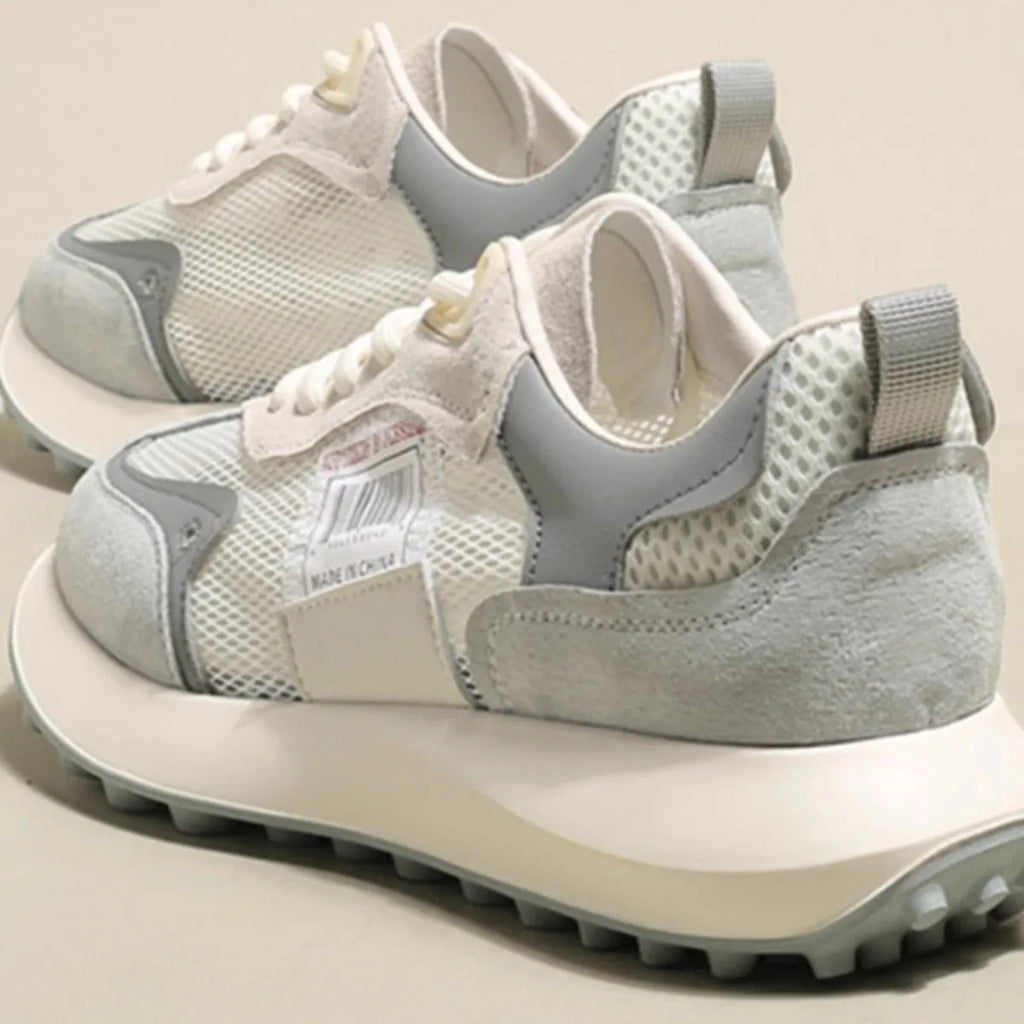 Women's grey retro sneaker with round toe and rubber sole showing mesh lining interior