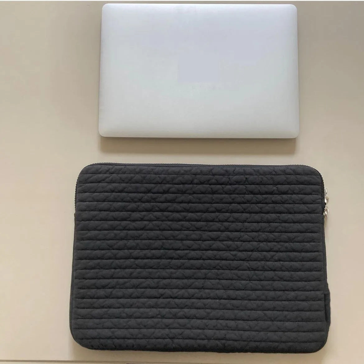 Black and white hand-held anti-seismic cotton laptop clutch bag for tablets, showing coin pocket.