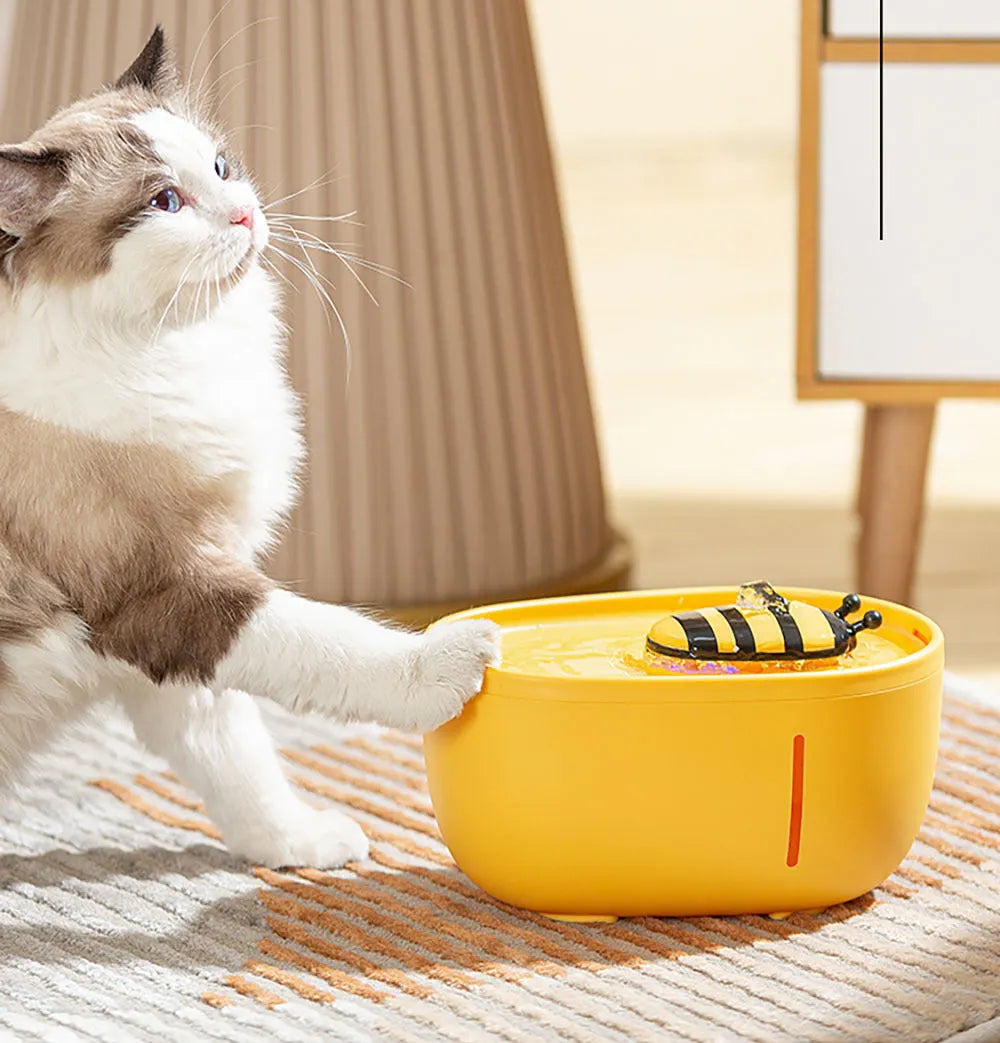 Yellow cat water fountain with filtration system, blue LED light, and water level window.