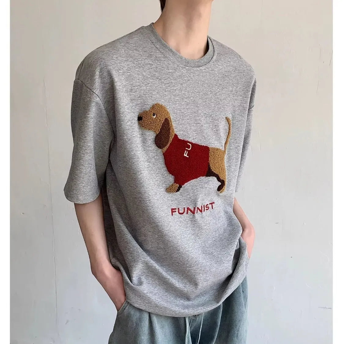 Grey men's cotton T-shirt with an embroidered cartoon dachshund holding a towel.
