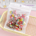 50 colourful cartoon mini erasers in pearlescent bags showing fruit, animal, and holiday designs