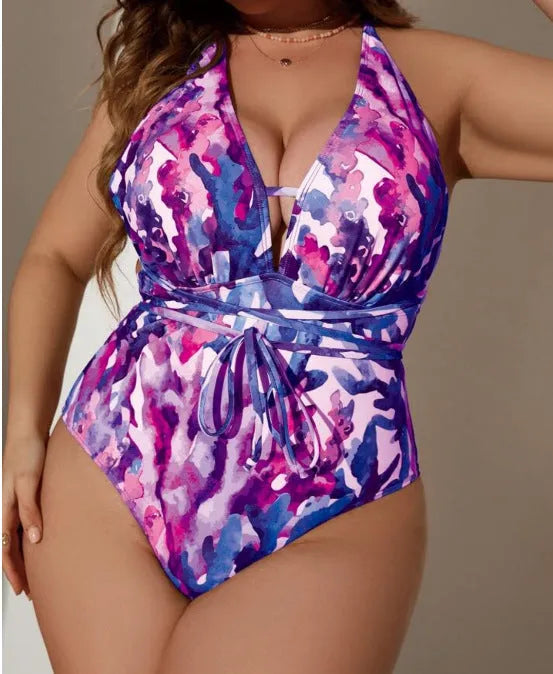 A purple women's one-piece halter swimsuit with a brief style, laid flat.