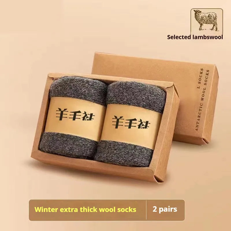 Two pairs of thick grey winter wool socks with a merino midsole next to a storage box