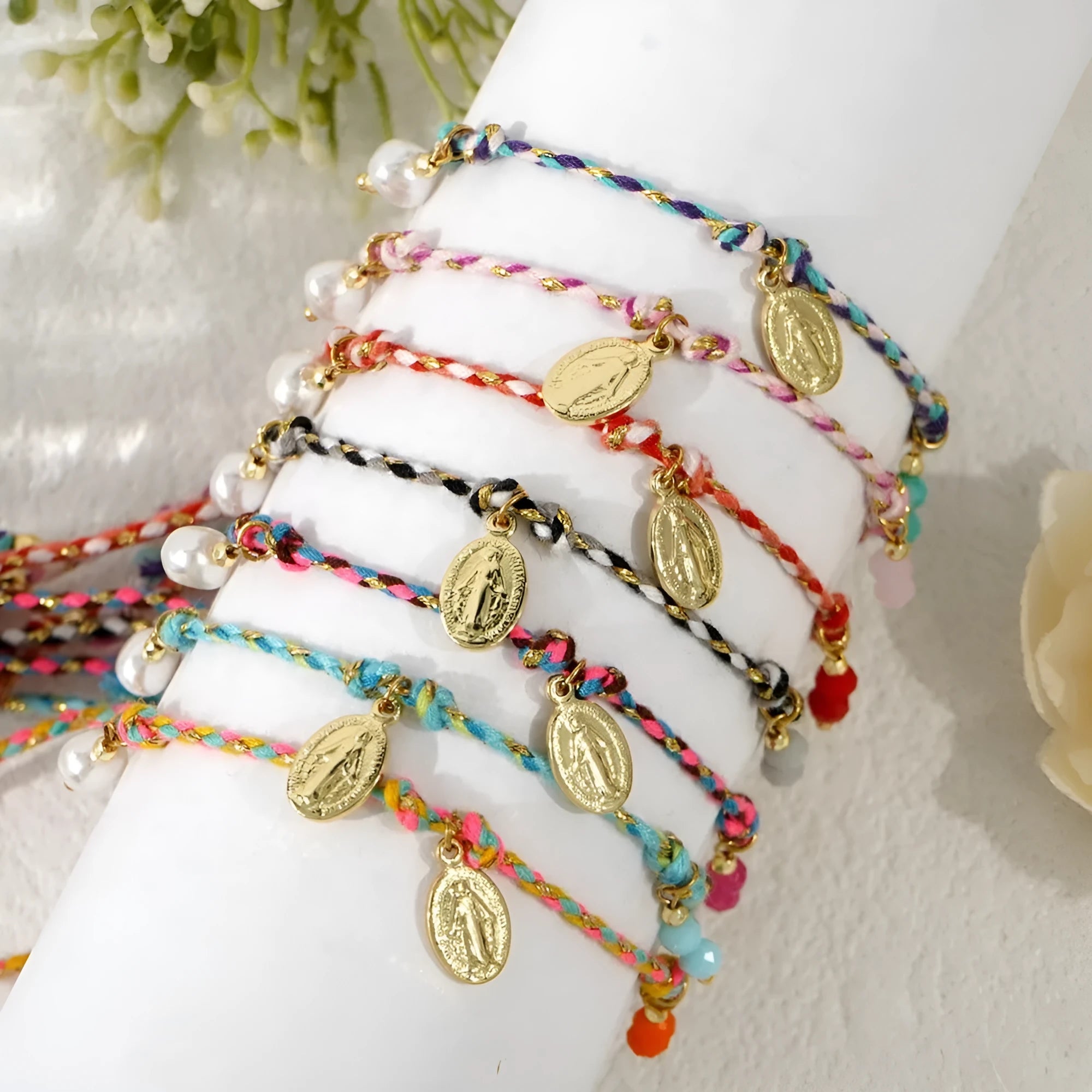 Close-up of a woman's hand-woven colourful braided rope bracelet with an adjustable strap tag.