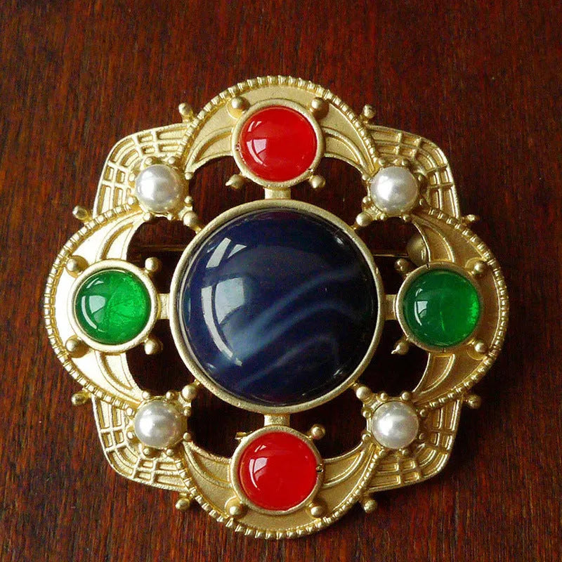 A vintage-style baroque brooch made of zinc alloy in a diamond shape on a fabric background.