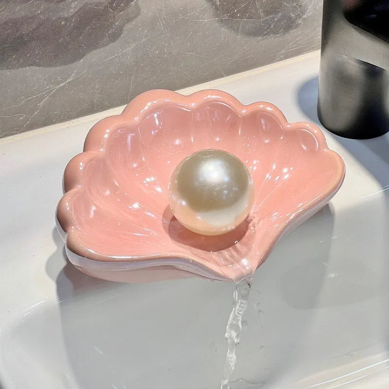 White shell-shaped plastic soap dish on a bathroom countertop.