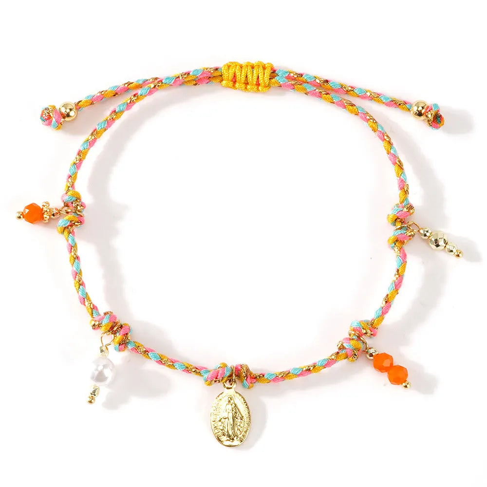 Close-up of a woman's hand-woven colourful braided rope bracelet with an adjustable strap tag.