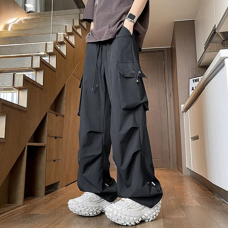 A woman wearing thin, loose, straight-leg waterproof trousers in a solid colour with an elastic drawstring waist.