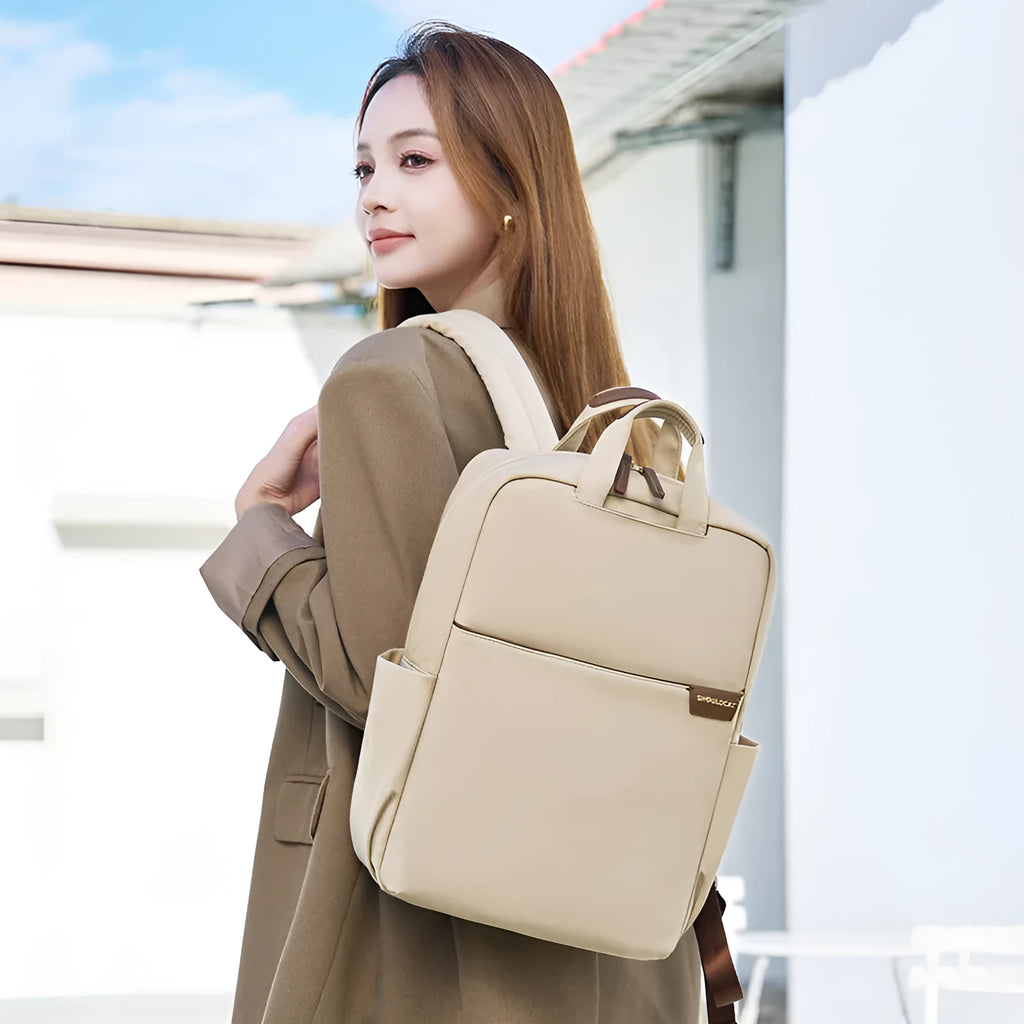 Nylon women's travel backpack in apricot colour showing front pockets and laptop compartment.