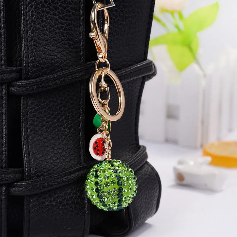 Green zinc alloy watermelon-shaped keychain on a white background.