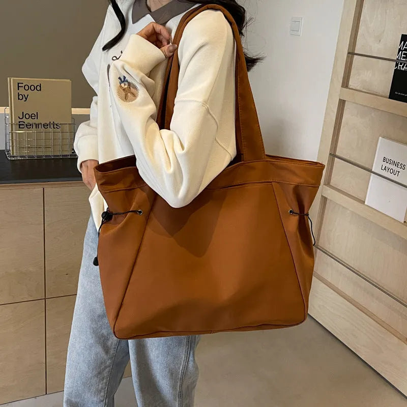 Soft oxford cloth folding commuter tote bag in street style, shown in black, grey, brown, and purple colours.