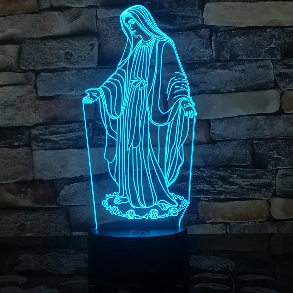 3D LED night light with colourful dual-ring pattern, remote control, and USB cable on a desk.
