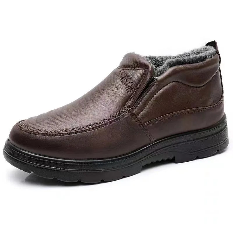 Men's black fleece-lined winter slip-on shoes with rubber sole on a wooden floor.