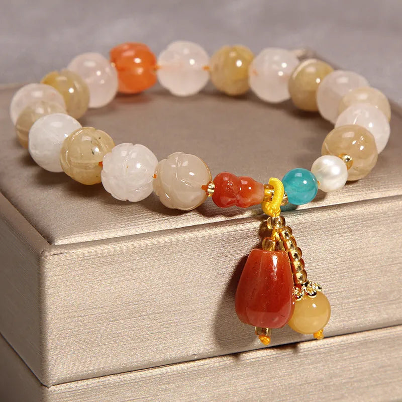 Yellow agate crystal bracelet with gold silk cord and adjustable sliding knot on a wrist.