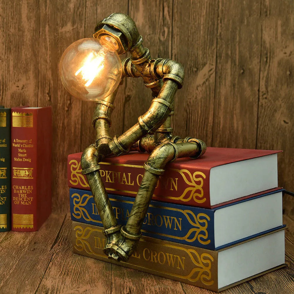 Green bronze vintage industrial robot desk lamp with iron pipe design on a wooden table.