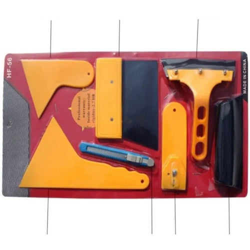 Seven-piece car film tool set with scrapers, knives, and a pressing block on a work surface.