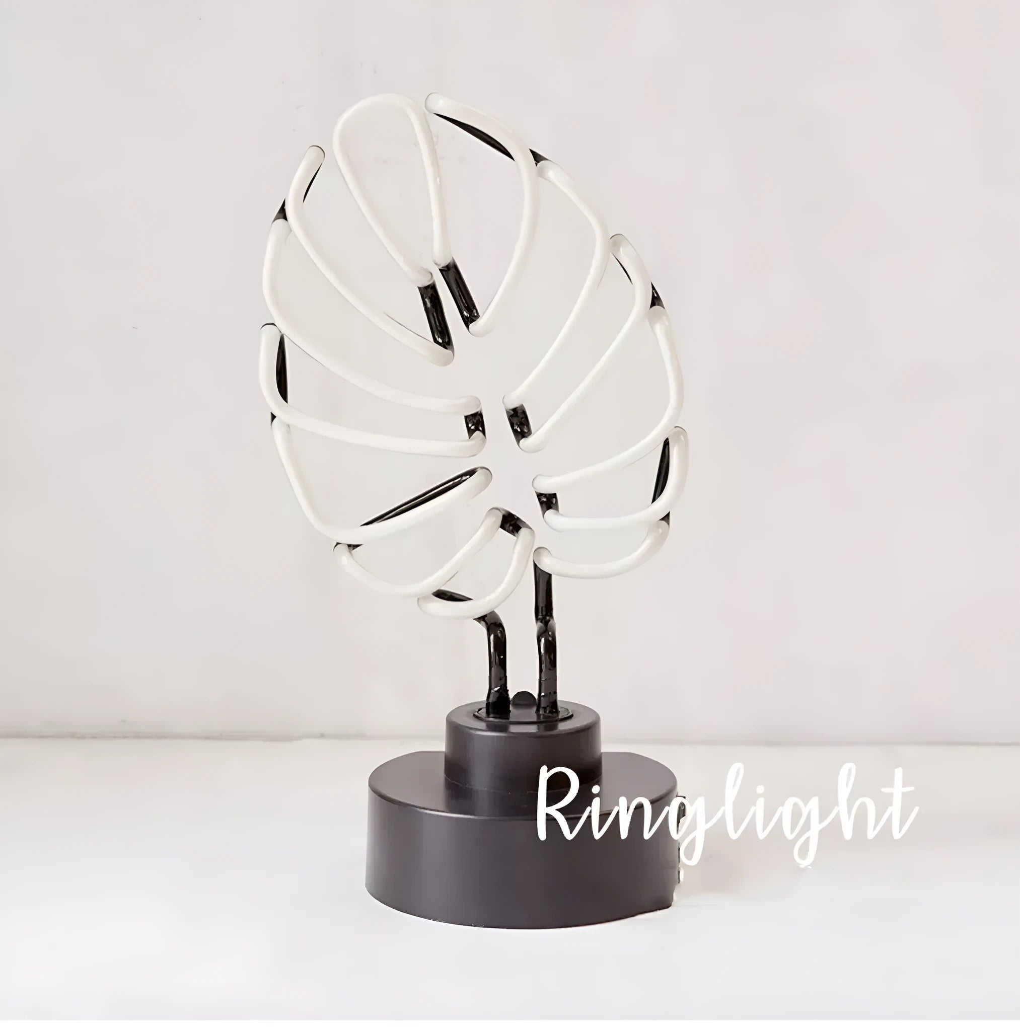 Minimalist white bamboo-shaped desk lamp emitting a soft green LED light, with a black USB cable.