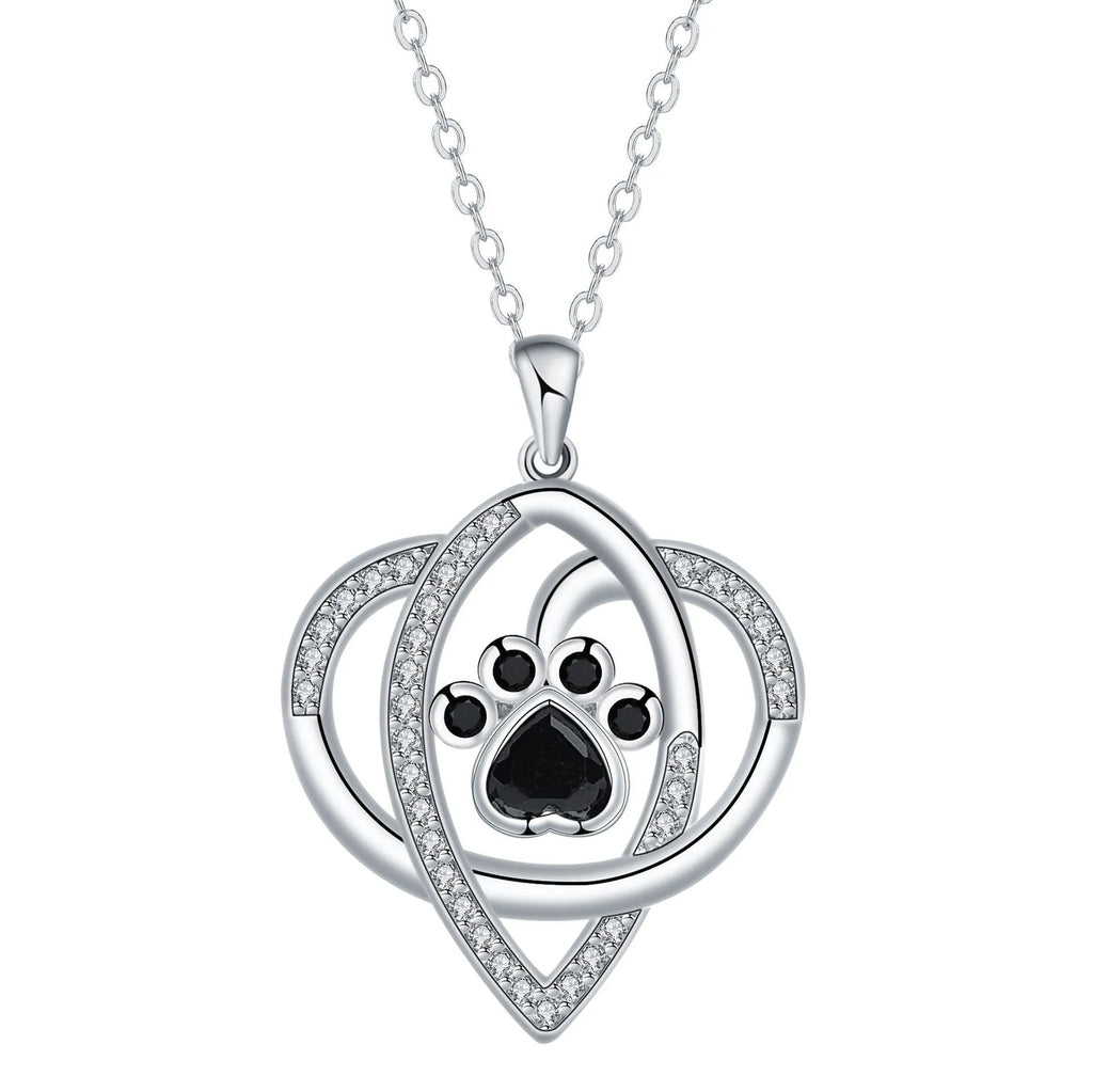 Close-up of a copper necklace pendant showing detailed dog and cat paw prints on a cross chain.