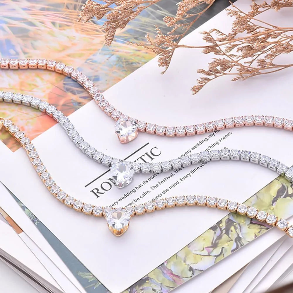 Gold rhinestone heart-shaped collar for dogs and cats with shiny stones and metal extension chain.