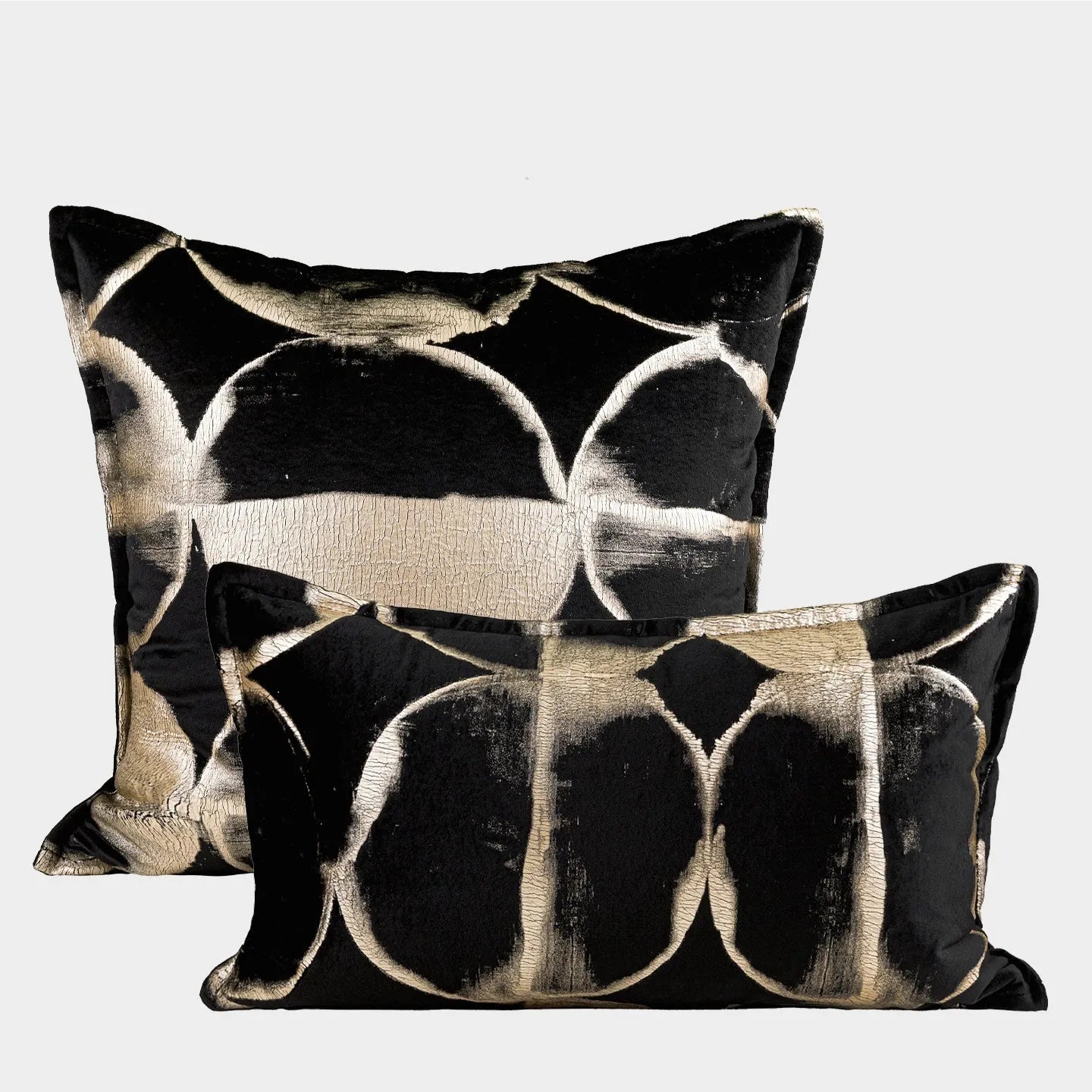 Black and gold abstract patterned flannel sofa cushion with removable cover on a grey sofa.
