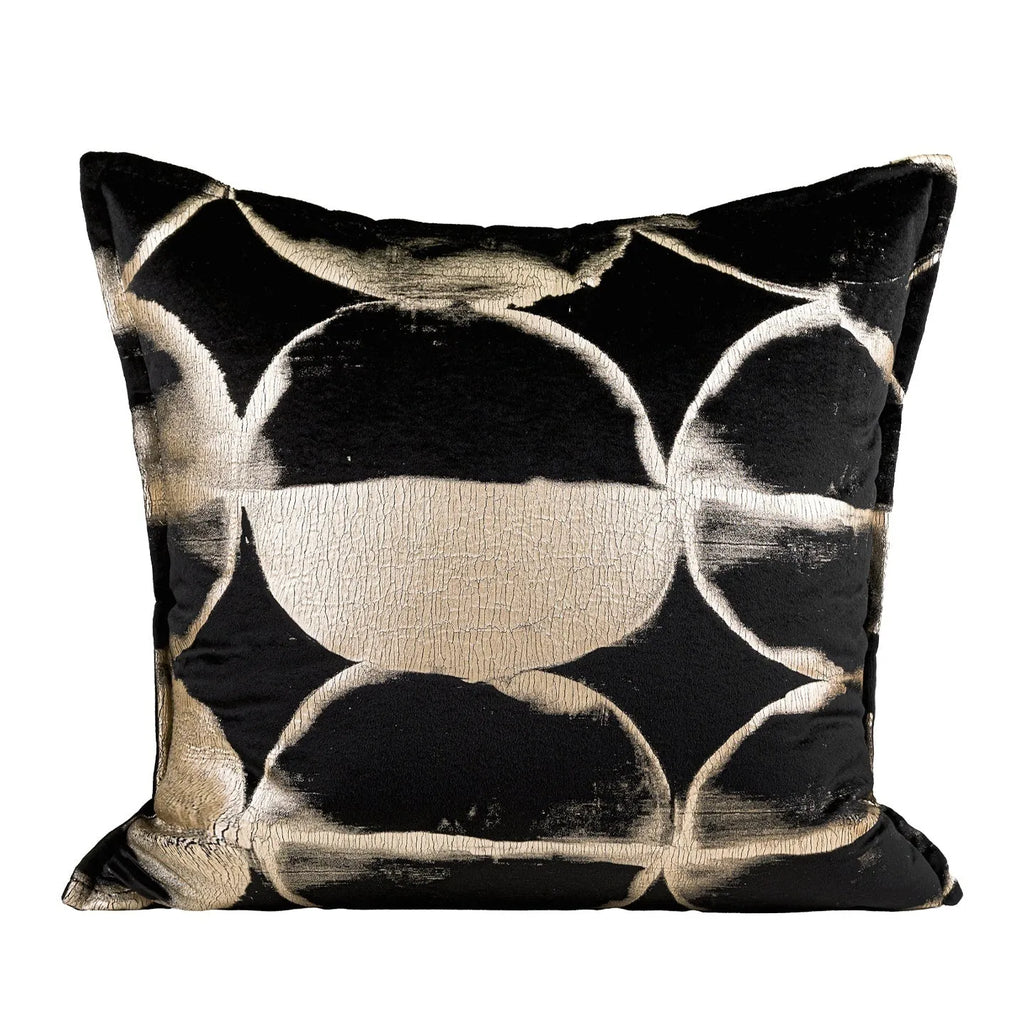 Black and gold abstract patterned flannel sofa cushion with removable cover on a grey sofa.