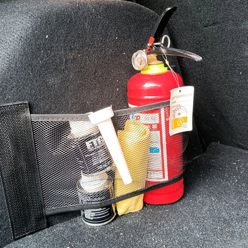Elastic polyester storage net stretched in a car boot, holding shopping bags.