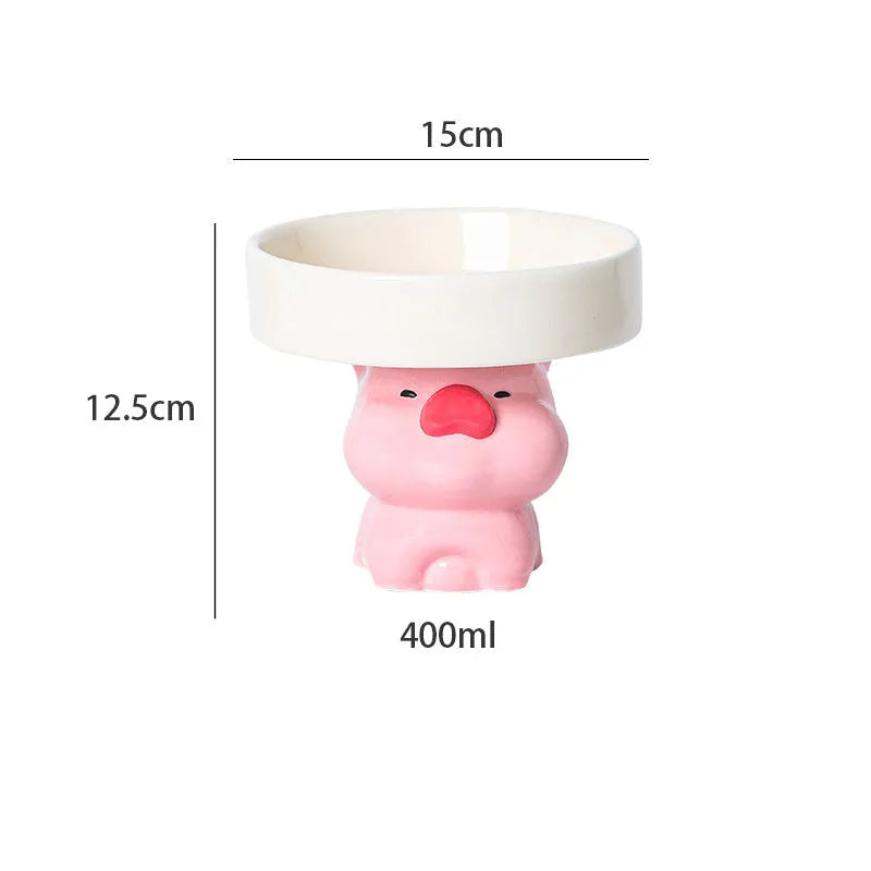 Raised ceramic cat bowl with animal design in pink, yellow, or white on a wooden floor.