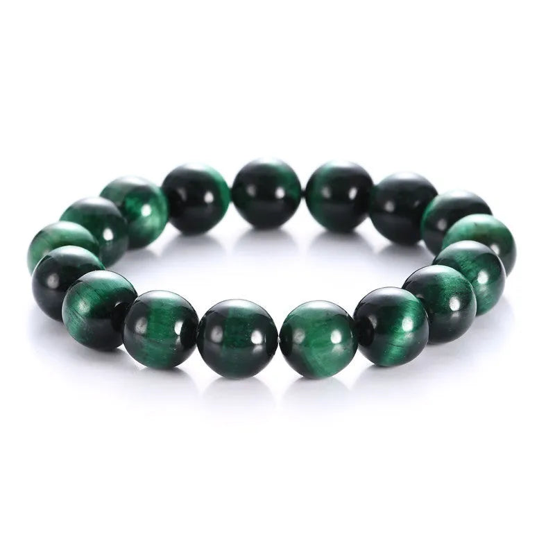 Green tiger eye stone bracelet with geometric beads on a wrist.