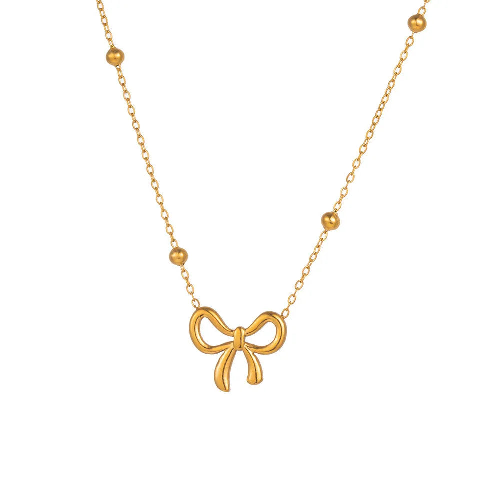 Gold electroplated bow necklace on a titanium steel cross chain, adjustable from 41 to 50 cm.