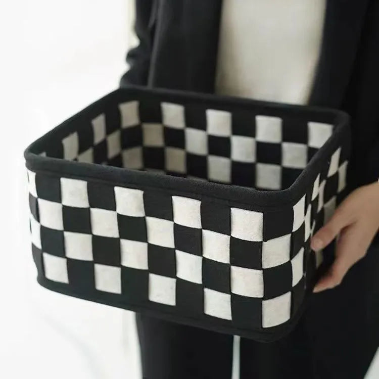Checkerboard patterned grey and white felt folding storage box with woven design.