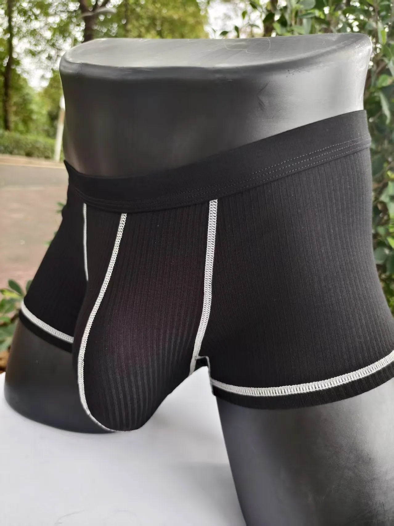 Solid-colour men's boxers in breathable fibre fabric on a size chart.
