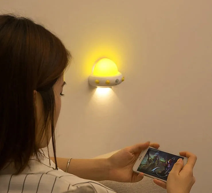 Remote control UFO shaped bedside night light in blue, pink, or white colour.