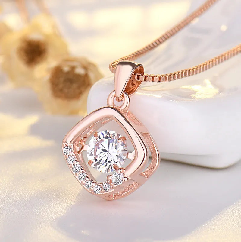 Heart-shaped sterling silver necklace with crown and bow charms on model