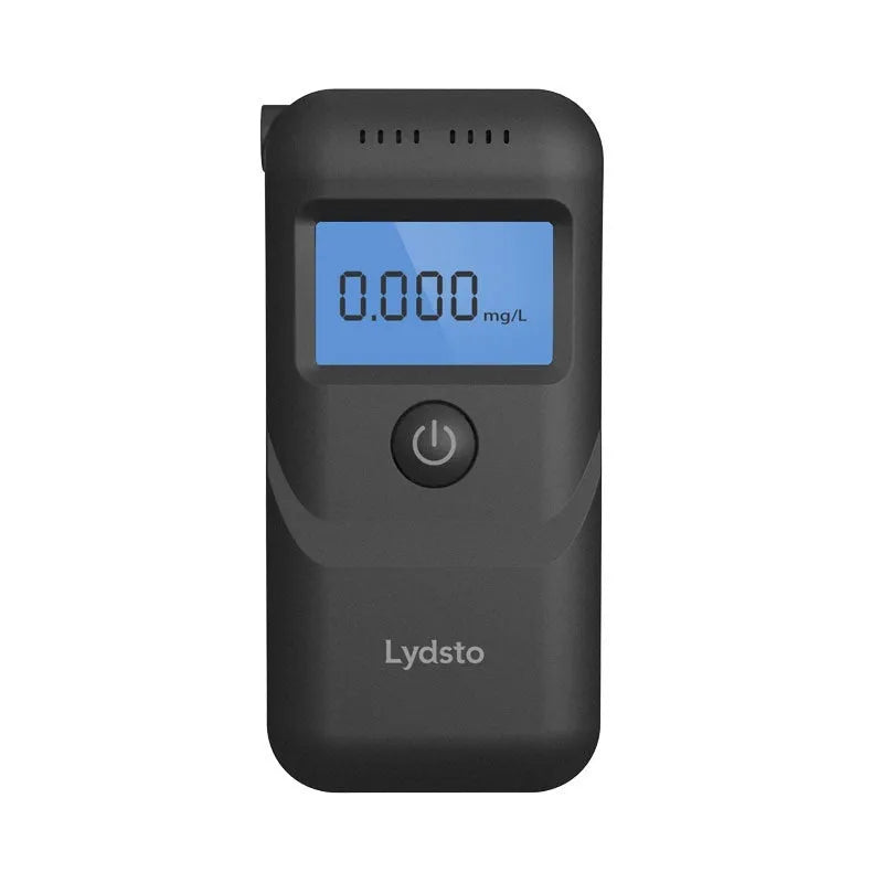 Black portable household alcohol breath tester with LCD screen on a dark background.