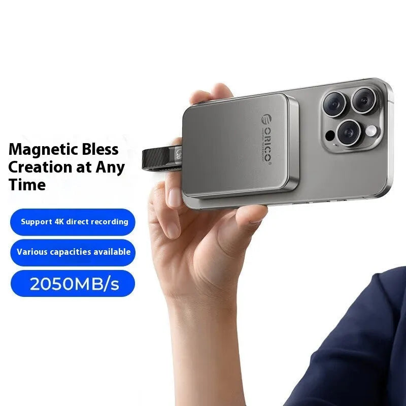 Grey magnetic mobile solid state drive with ultra-thin design next to C to C cable and magnetic suction ring