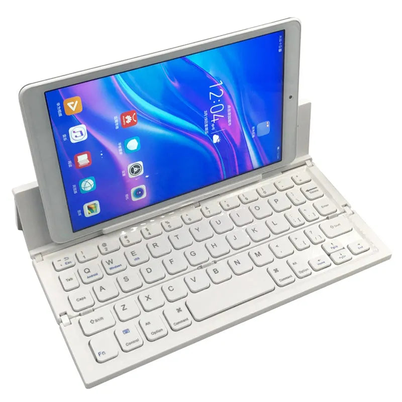 Black folding wireless Bluetooth keyboard unfolded next to tablet showing mini keyboard size