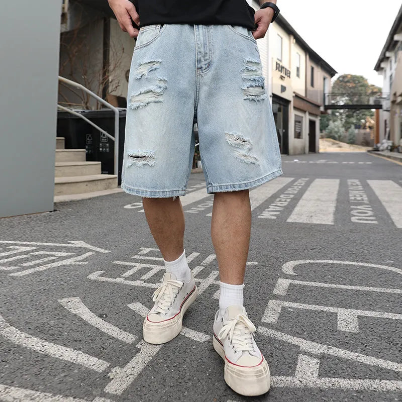 Light blue ripped denim shorts with distressed details and straight leg cut in hip hop streetwear style