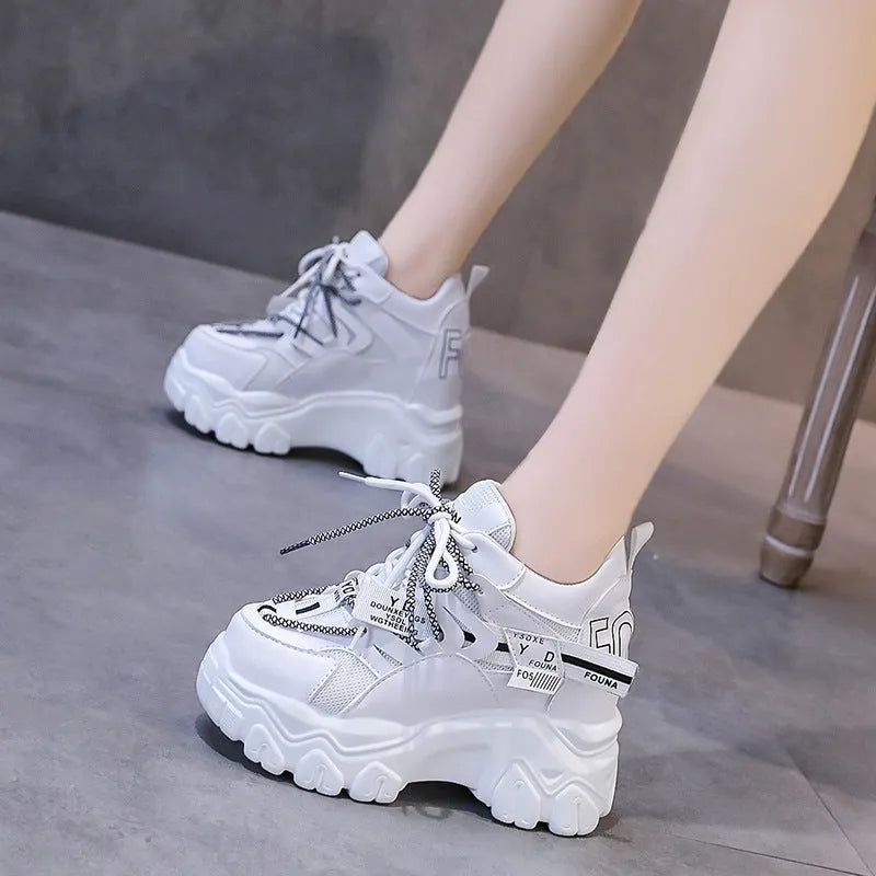 White and black women's low-top mesh platform sports shoes with cross strap and round toe.