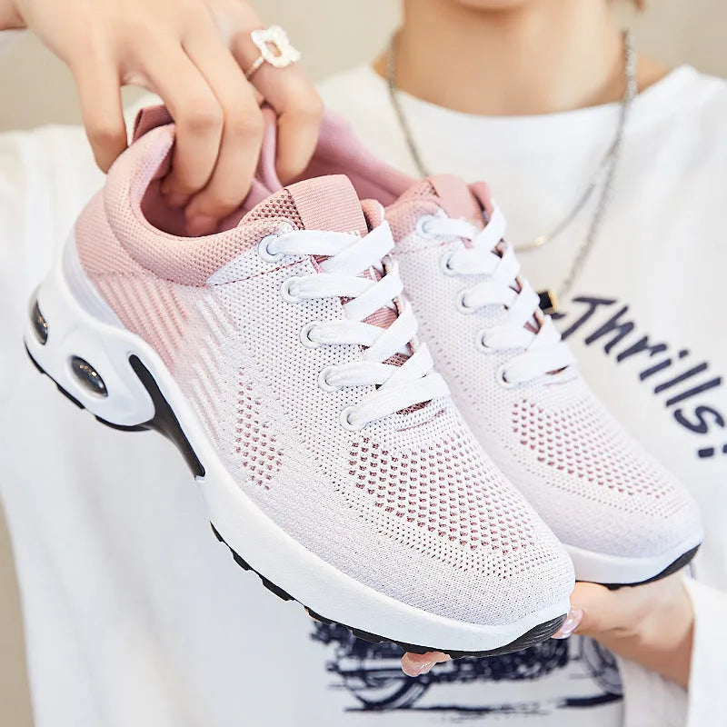 Women's pink Flyknit casual running shoes with mesh lining and flat heel on a white background